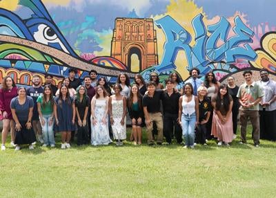 group of RISE students in front of Rice graffiti wall