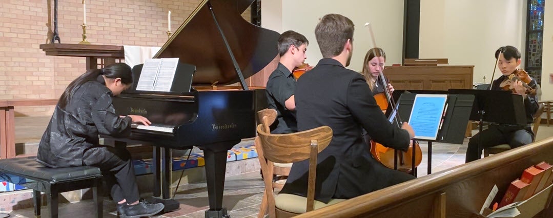 Students from local high schools perform a piece composed by a fellow musician. 
