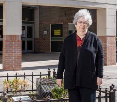 Diane Wofthal in front of Phillis Wheatley High School